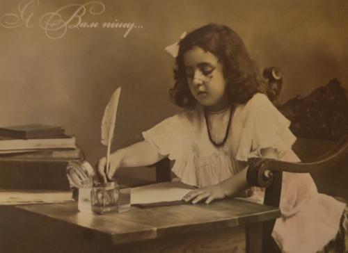 Vintage photo of a little girl with a quill pen.