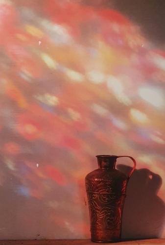 Antique vase on a wooden table with a blurred background.