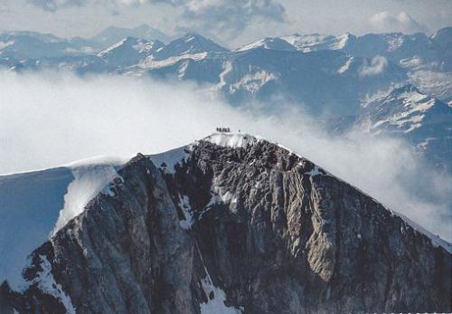 Aerial view of a mountain peak covered with snow and fog.