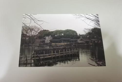 A picture of a Japanese house in the middle of a lake.