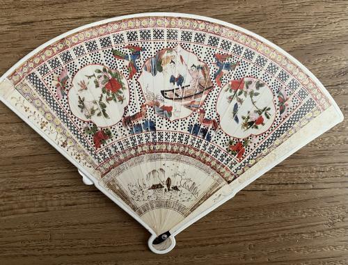 Spanish hand fan on a wooden background, close-up, top view