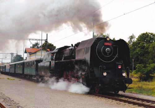 Old steam locomotive with smoke coming out of the engine compartment.
