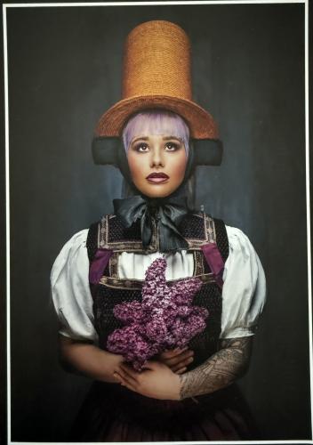 young pretty woman with purple hair in hat with lilac on black background