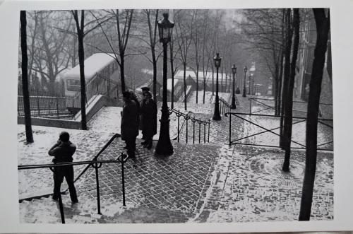 A black and white photo of two women walking in a winter park