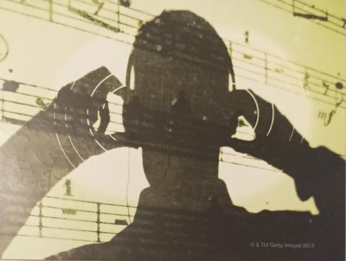 Double exposure of a silhouette of a man listening to music with headphones.