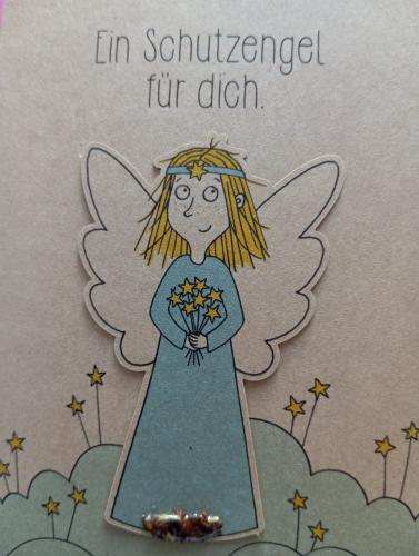 Christmas card with angel and snowflakes on a gray background.