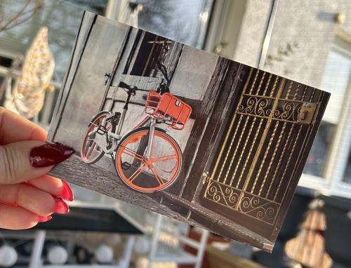 Woman's hand with red manicure holds a photo of a vintage bicycle.