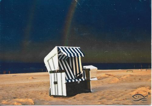 Beach chair on the beach with rainbow in the background. Photo in old image style.
