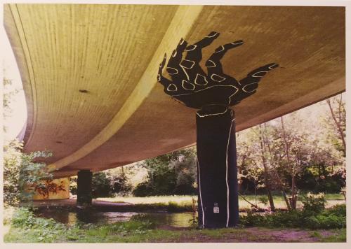 Vintage photo of a hand in front of a viaduct