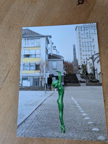 Sculpture of a man in the form of an alien on a city street