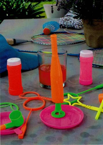 Badminton equipment and glass of water on the table in the garden