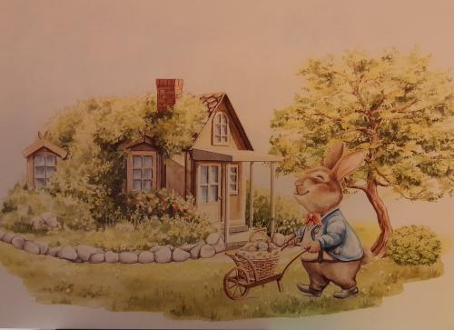 Rabbit with a cart on the background of a country house.