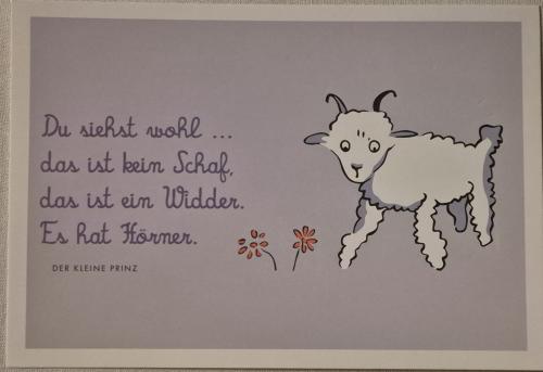 Handmade paper craft of a goat with flowers on a gray background