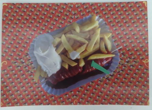 Fried hot dog and french fries on a red background, top view