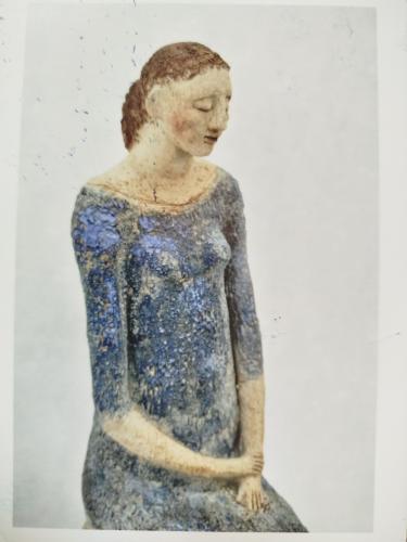Ceramic figurine of a young woman in a blue dress