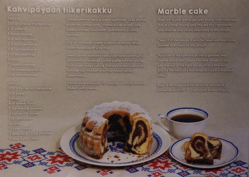 Cup of coffee and chocolate cake on a table with a menu