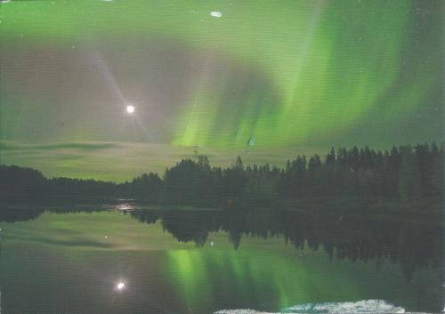 Aurora borealis, northern lights over lake in Finland.