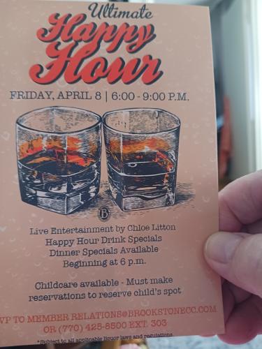 A man holding a glass of whiskey in front of a menu.