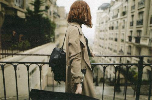 An antique photo of a woman with a suitcase