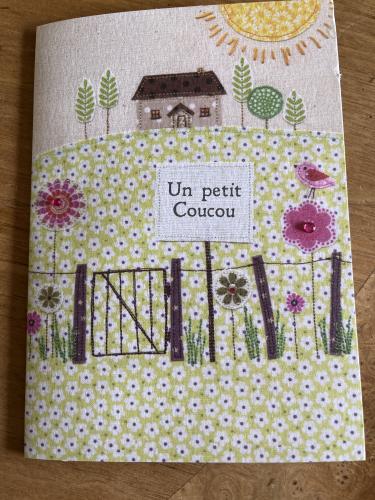 Handmade patchwork in the shape of a house on a wooden background