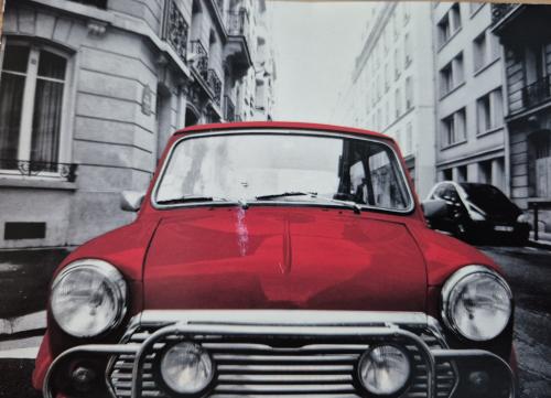 Old red car on a street in Prague, Czech Republic. Photo in old color image style.