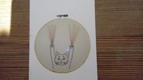 A cat in a cage made of rope. Handmade craft.
