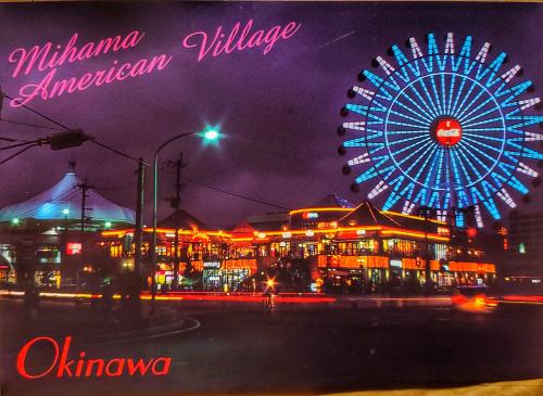 Amusement park at night with ferris wheel and lights.