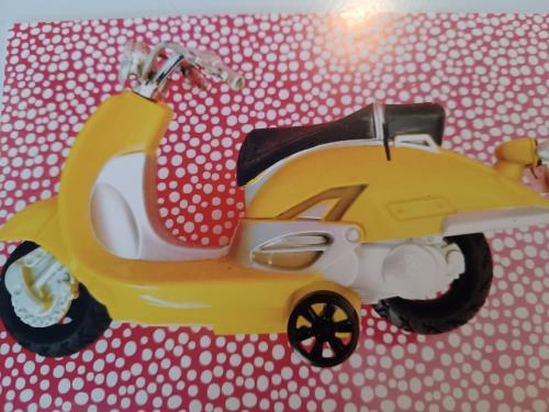 Yellow scooter on the background of a polka dot fabric.