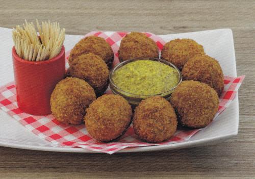 Breaded falafel balls with green chutney on wooden table