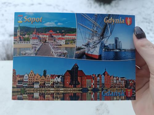 A hand holds a postcard from Copenhagen.