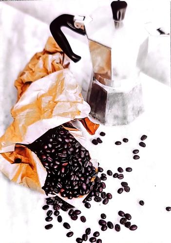 Coffee maker and coffee beans on a white background. Coffee beans in a paper bag.