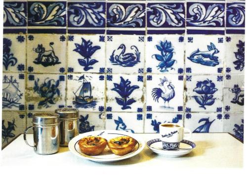 Coffee and cakes on a table with a blue ceramic tile background