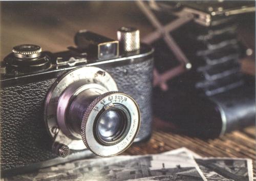 Vintage camera and old photos on a wooden background. Selective focus.