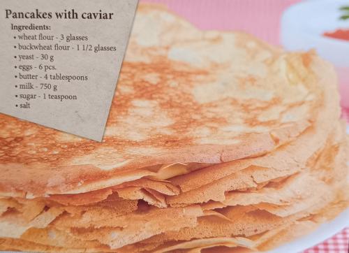 A stack of crepes in a plate on a pink background.