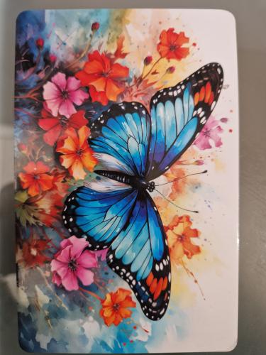 Butterfly on a painted plate with flowers in the background.