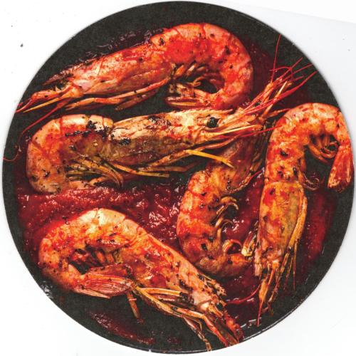 Shrimps with tomato sauce in a black plate on a white background