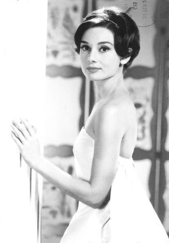 A vintage black and white photo of a beautiful woman in a white dress.
