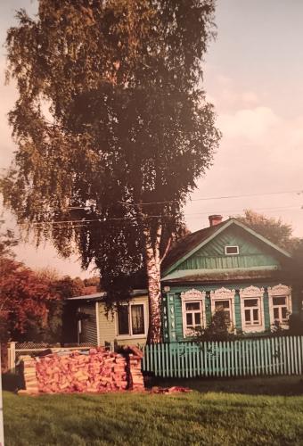 Old wooden house on the background of the autumn landscape. Photo in retro style.