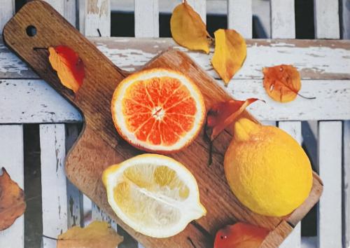 Lemon, orange and grapefruit on a wooden cutting board.