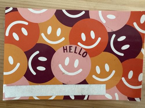 Hello card with smiley faces on wooden background. Happy and smiling.