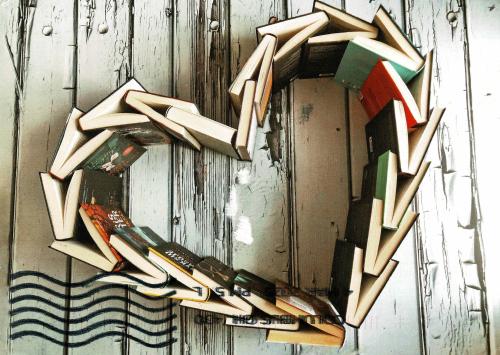 Heart made of books on wooden background. Love and romance concept.