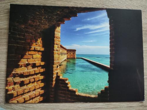 Vintage photo album with sea view on old brick wall background.