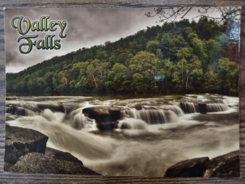 A picture of a waterfall in the middle of the forest with a text