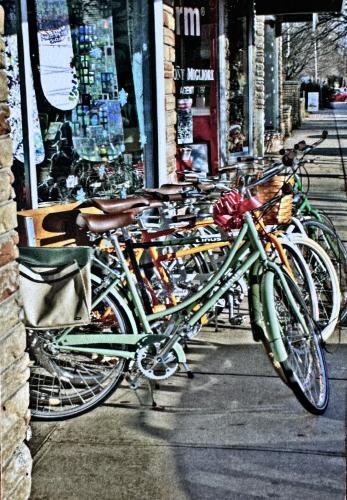 Bicycles parked in a row in front of a shop window
