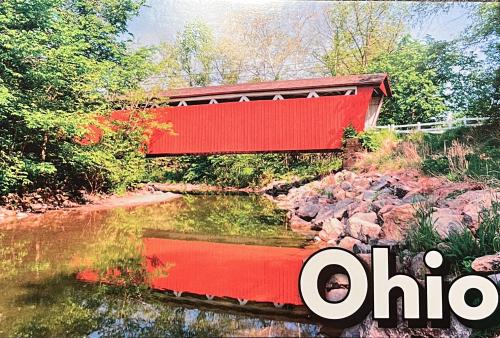 Wooden bridge over a river in the countryside with red roof.
